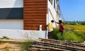 Workers setting up bamboo scaffolding for exterior wood cladding installation, construction management by Walls Asia in Hyderabad